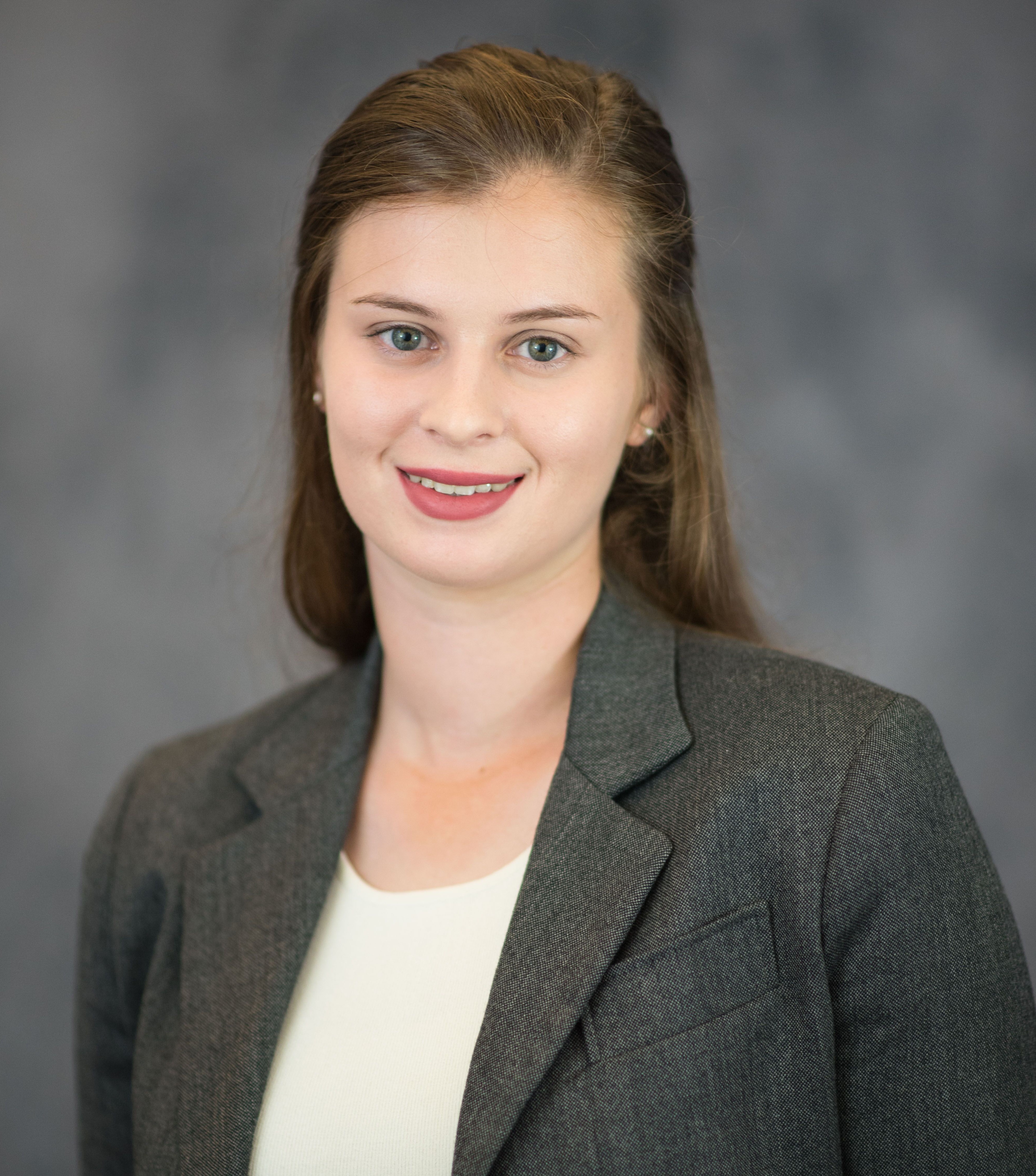 A photo of Anna Schmult, wearing a grey blazer.